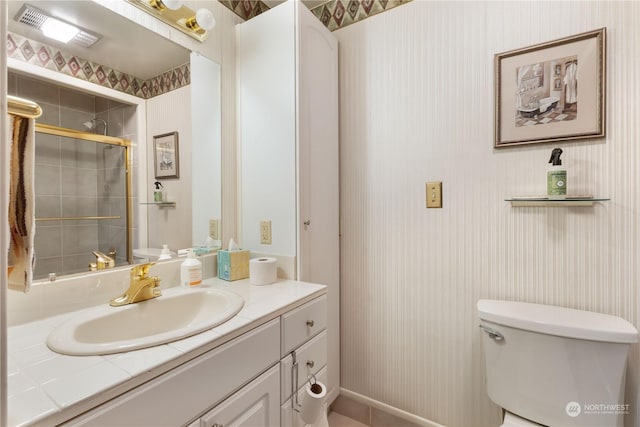 bathroom with vanity, toilet, and a shower with shower door