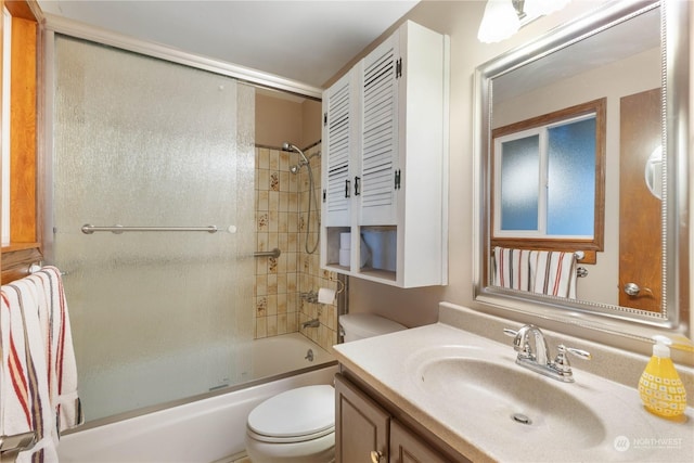 full bathroom with bath / shower combo with glass door, vanity, and toilet