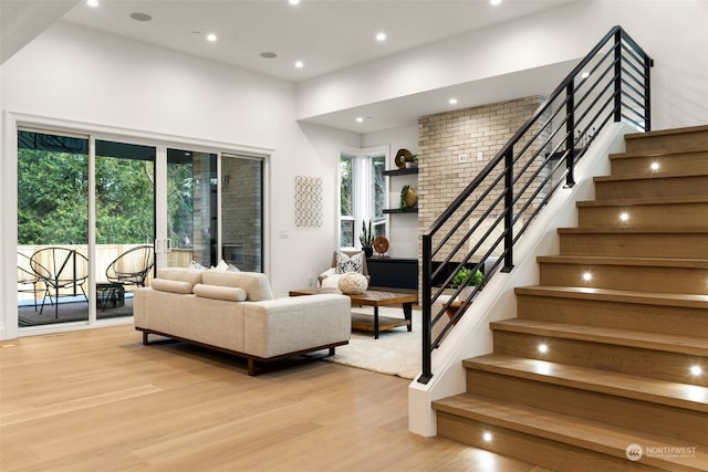 living room featuring light hardwood / wood-style floors, a high ceiling, and a wealth of natural light