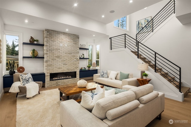 living room featuring light wood-type flooring and a brick fireplace