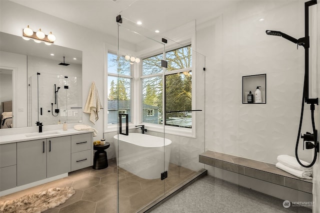 bathroom with independent shower and bath, tile patterned flooring, a wealth of natural light, and vanity