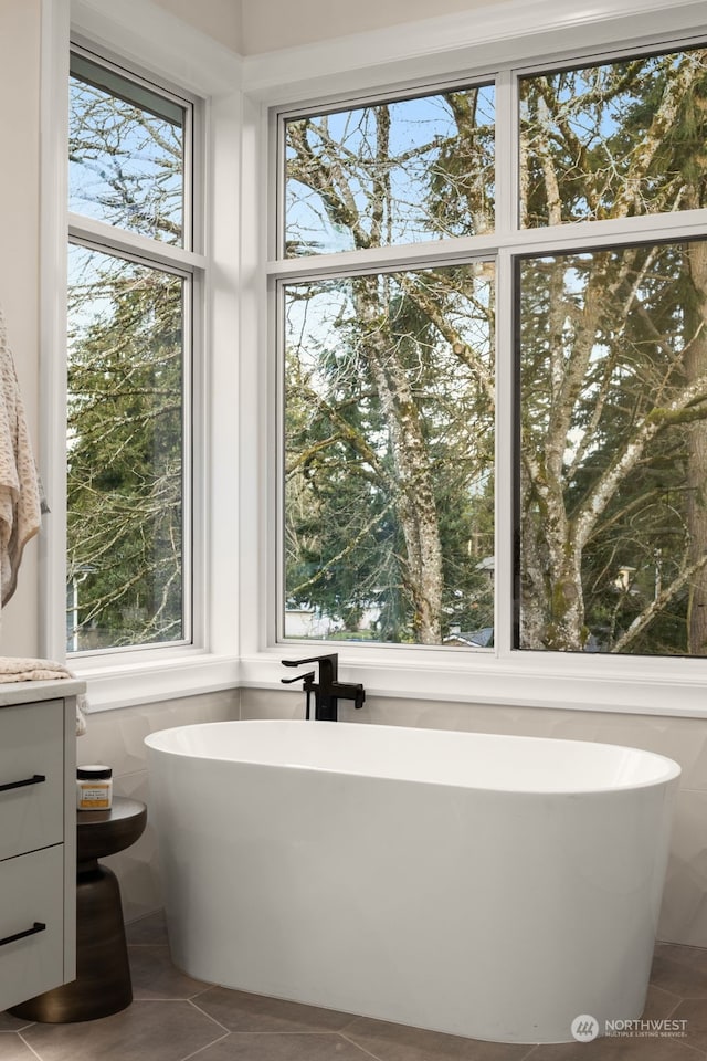 bathroom with a bathing tub, tile patterned flooring, and vanity