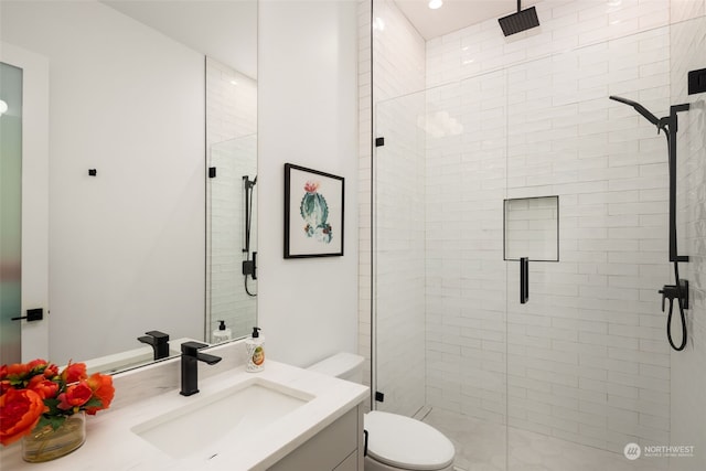 bathroom featuring toilet, vanity, and walk in shower