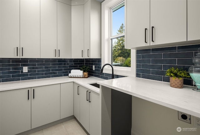 kitchen featuring sink, light tile patterned floors, plenty of natural light, and tasteful backsplash