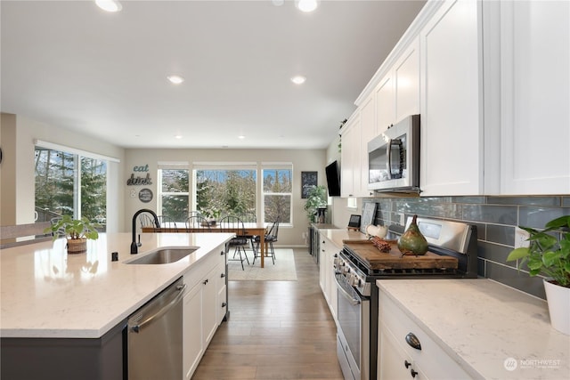 kitchen with appliances with stainless steel finishes, sink, and white cabinets