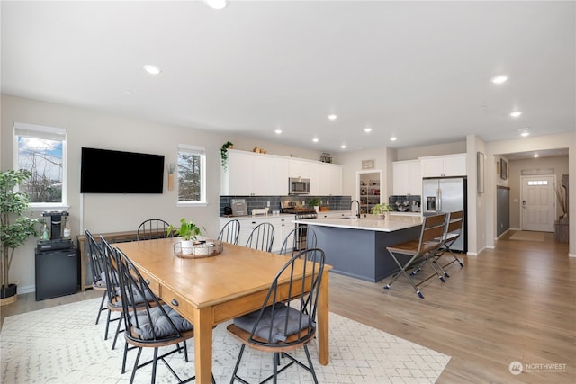 dining space with sink and light wood-type flooring