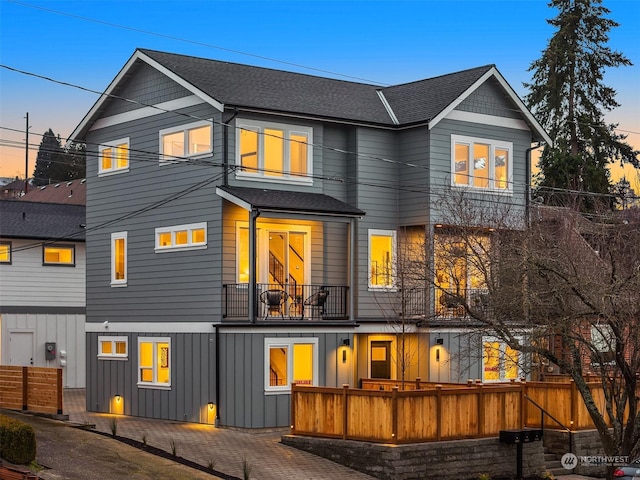 back house at dusk with a balcony