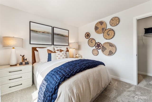 bedroom featuring a walk in closet, a closet, and light carpet