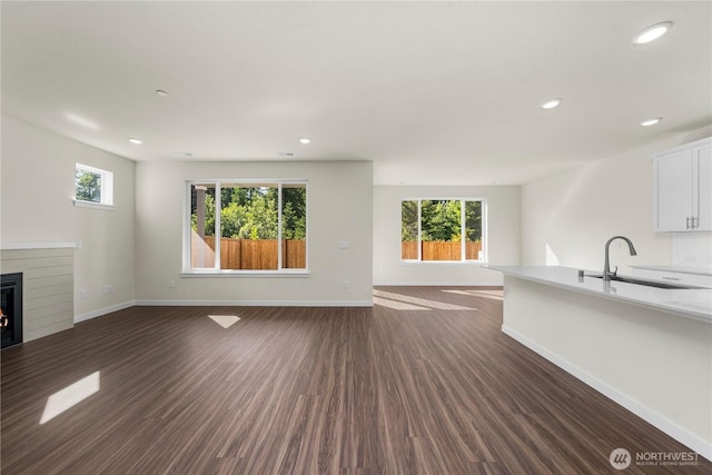 17920 139th Pl E, Puyallup, WA 98374 - unfurnished living room featuring dark wood-style flooring, healthy amount of natural light, baseboards, and recessed lighting