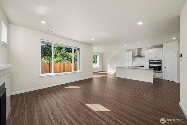 17920 139th Pl E, Puyallup, WA 98374 - unfurnished living room featuring a fireplace, baseboards, dark wood-style flooring, recessed lighting, and a sink