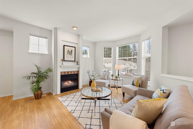 living room with a tile fireplace and light wood-type flooring