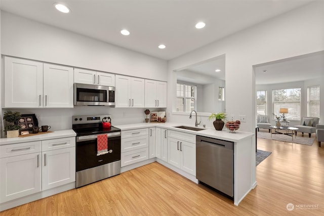 kitchen with sink, stainless steel appliances, and white cabinets