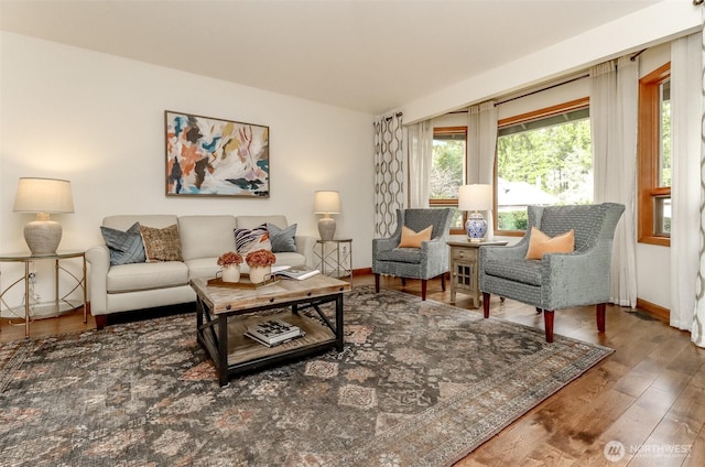 living room featuring a wealth of natural light, baseboards, and wood finished floors