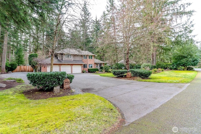 view of front facade featuring brick siding, driveway, a front yard, and an attached garage