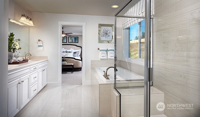 bathroom featuring ceiling fan, independent shower and bath, and vanity