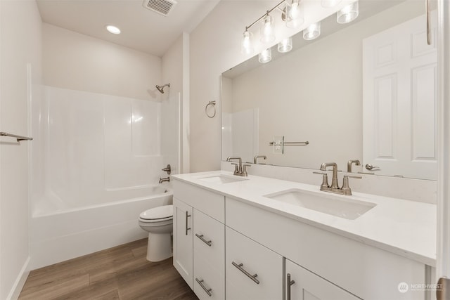 full bathroom with shower / tub combination, toilet, hardwood / wood-style flooring, and vanity