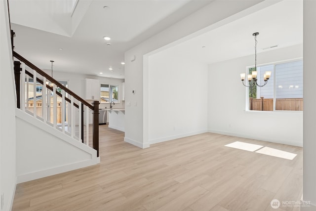 interior space with light wood-type flooring, stairway, baseboards, an inviting chandelier, and recessed lighting