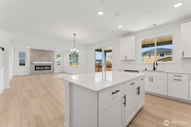 kitchen featuring light countertops, visible vents, a sink, and light wood finished floors