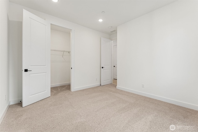 unfurnished bedroom featuring carpet floors, a closet, baseboards, recessed lighting, and a spacious closet