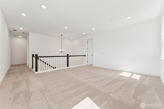 carpeted empty room featuring recessed lighting, baseboards, and a notable chandelier