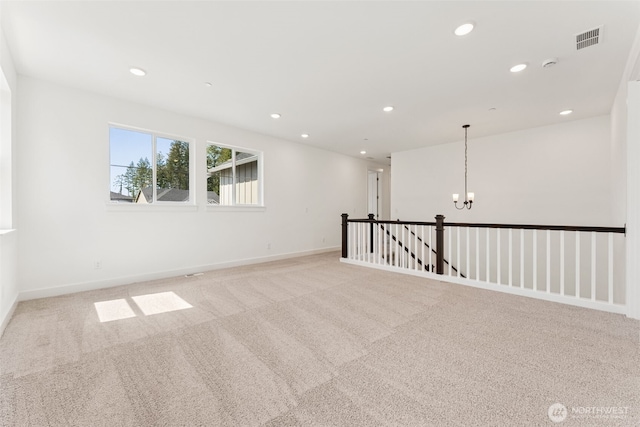 empty room with a chandelier, light colored carpet, visible vents, and recessed lighting