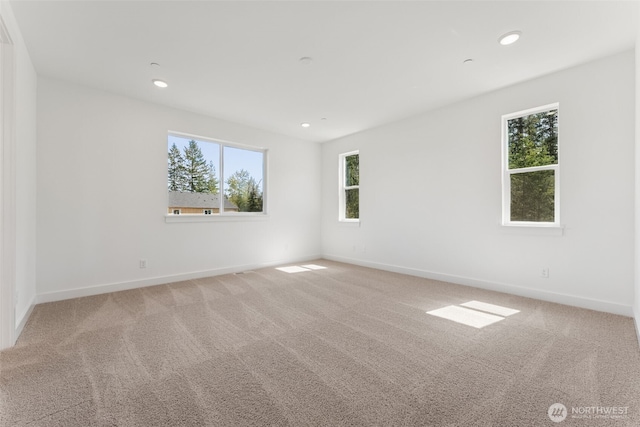 carpeted empty room featuring recessed lighting, baseboards, and a wealth of natural light