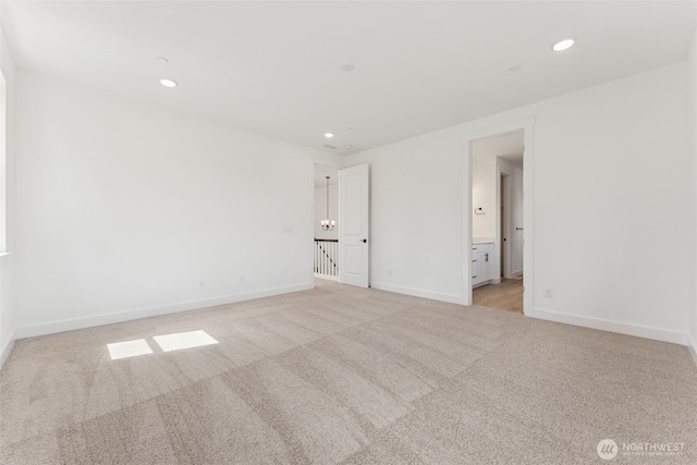 unfurnished room with recessed lighting, baseboards, and light carpet