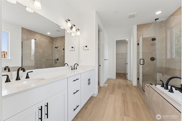 full bathroom with a sink, a healthy amount of sunlight, and a shower stall