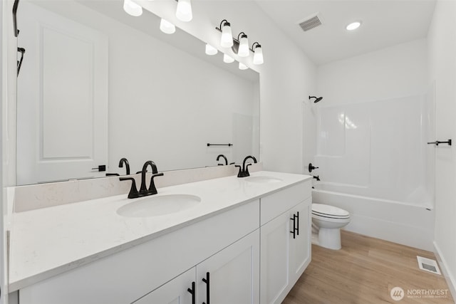 bathroom featuring a sink, toilet, double vanity, and visible vents