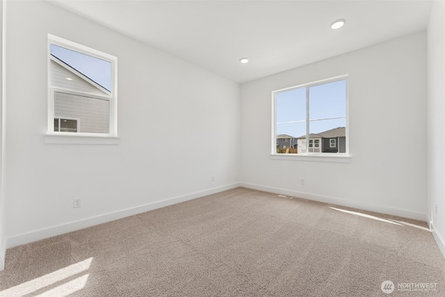 carpeted spare room featuring baseboards and recessed lighting