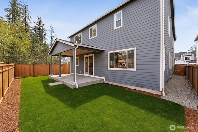 rear view of house with a fenced backyard, a patio area, and a yard
