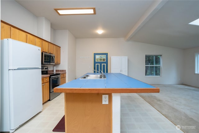 kitchen with sink, tile counters, an island with sink, light colored carpet, and stainless steel appliances