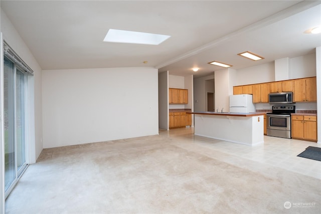 kitchen featuring a breakfast bar area, a wealth of natural light, stainless steel appliances, and a kitchen island