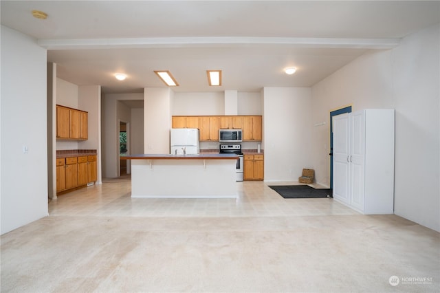 kitchen with light colored carpet, stainless steel appliances, a kitchen bar, and an island with sink