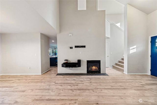 living room featuring light hardwood / wood-style floors and a towering ceiling