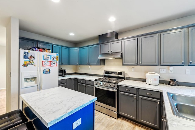 kitchen featuring sink, light stone counters, a kitchen island, light hardwood / wood-style floors, and stainless steel appliances