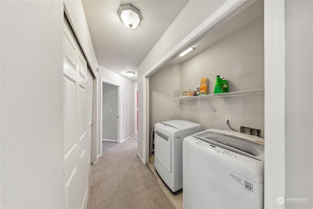 clothes washing area featuring light carpet and washer and dryer