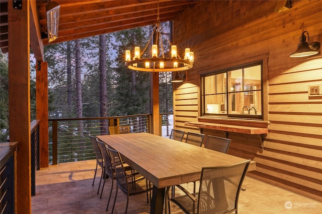 dining area featuring a chandelier and wood walls