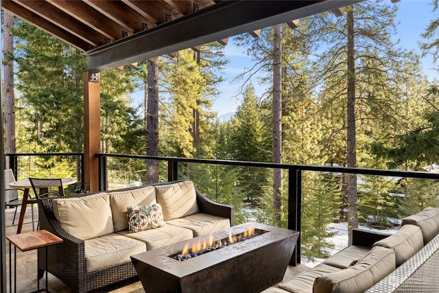 balcony featuring an outdoor living space with a fire pit