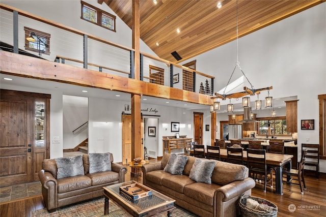 living room featuring hardwood / wood-style floors, wood ceiling, and a towering ceiling