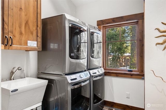 washroom featuring stacked washer and dryer, sink, and cabinets