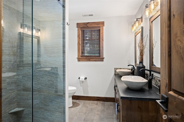 bathroom with walk in shower, vanity, and toilet