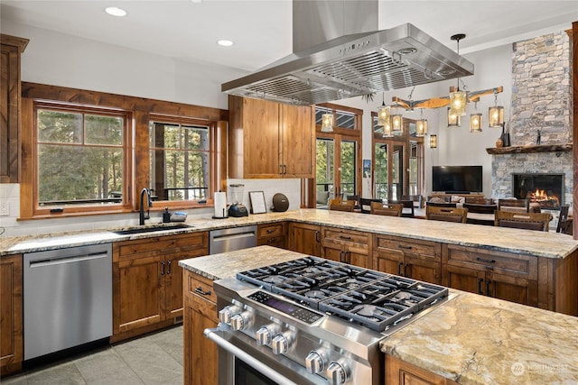 kitchen featuring stainless steel appliances, island exhaust hood, plenty of natural light, and sink