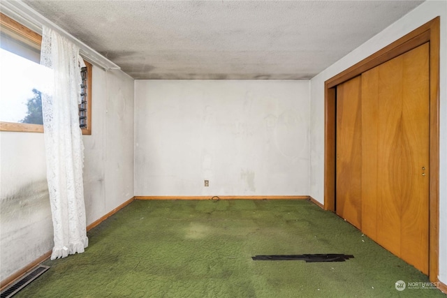 interior space with dark colored carpet and a textured ceiling