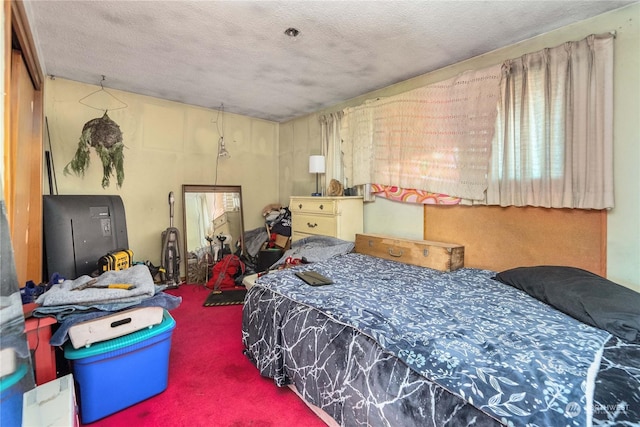 bedroom with a textured ceiling and carpet flooring