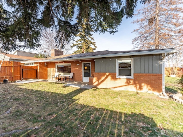 back of house with a patio area and a yard