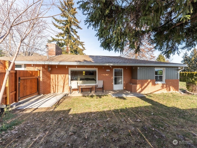 rear view of house featuring a lawn and a patio