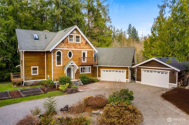 view of front of house featuring a garage and an outbuilding