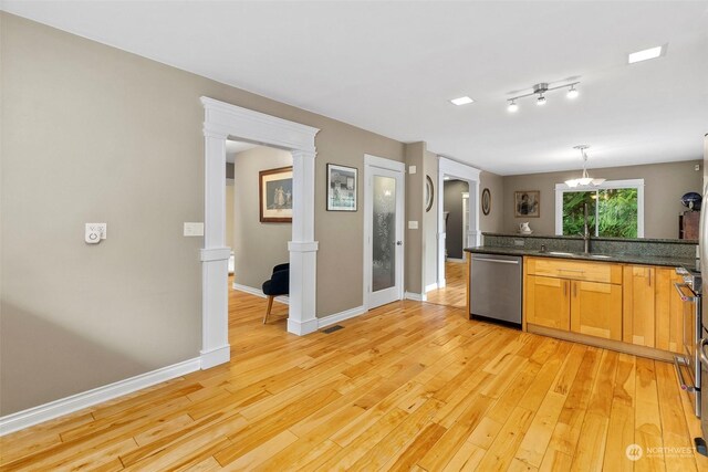 kitchen featuring light hardwood / wood-style flooring, pendant lighting, dishwasher, ornate columns, and sink