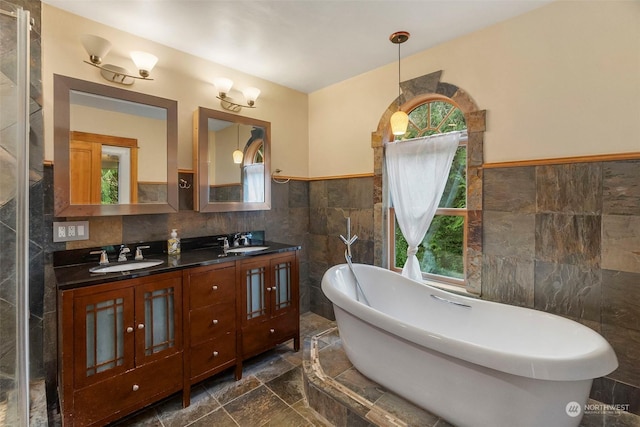 bathroom featuring a bath, tile walls, and vanity